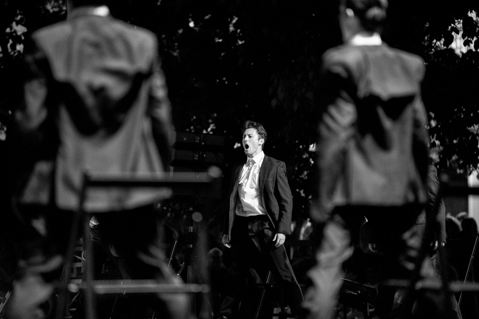 A powerful black and white image of a singer passionately performing on stage.